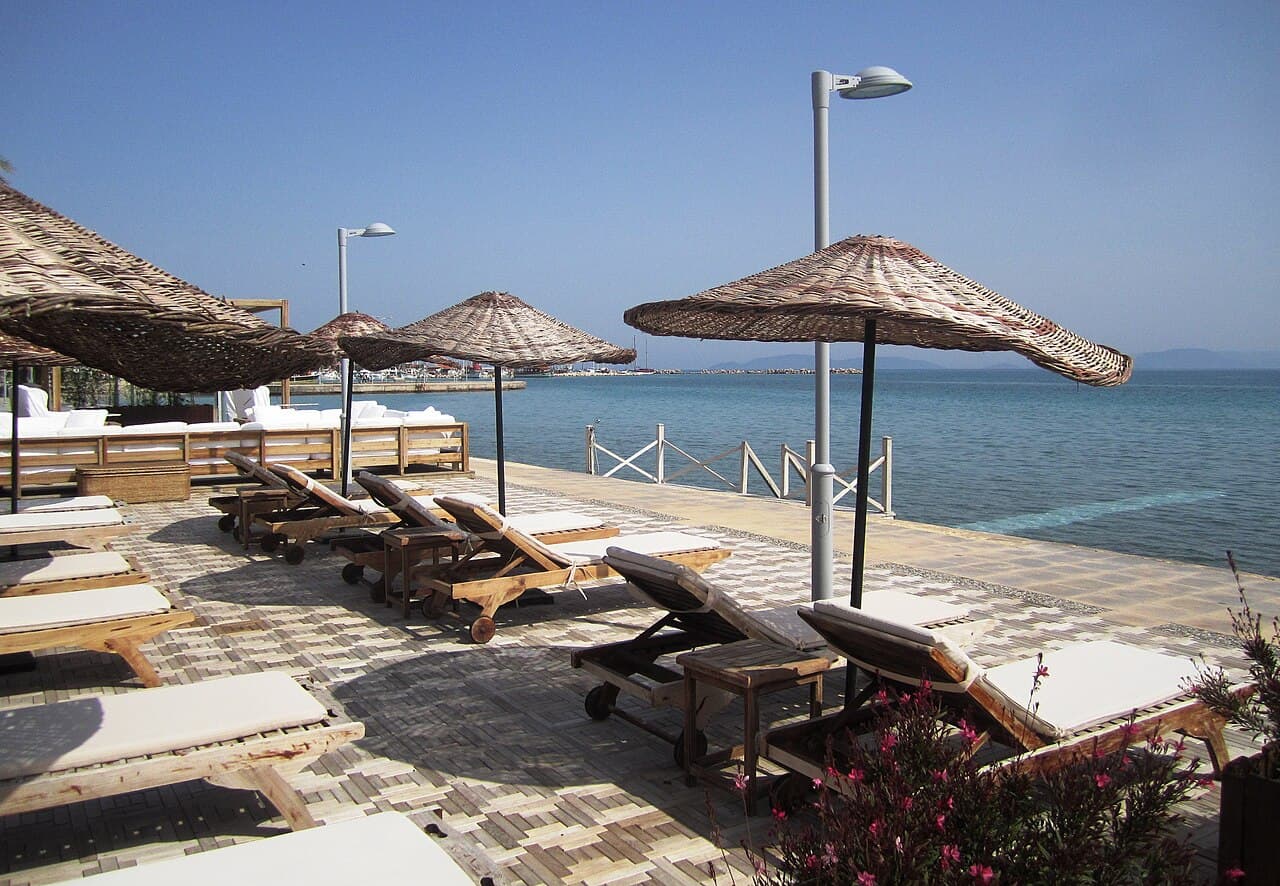Ilica beach in Cesme with clear Aegean water and beach umbrellas